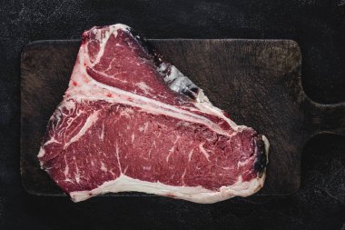 Raw T-bone Steak Kuru Vintage Kesme Kurulu Üzerinde Izgara veya Barbekü için Yaşlı