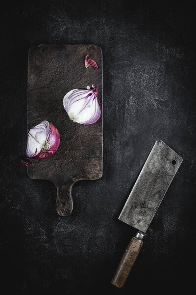 Halved Red Onion on Vintage Cutting Board with Meat Cleaver