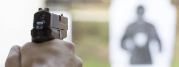 Mann feuert Pistole auf Scheibe im Schießstand — Stockfoto
