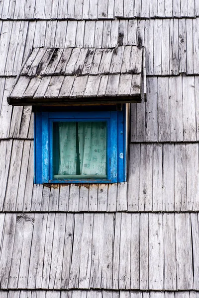 木质屋顶房屋上的旧蓝色窗户 — 图库照片