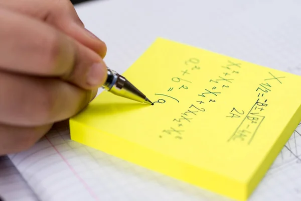 Bleistift in Kinderhand. Schreiben auf gelben Haftnotizen in Nahaufnahme — Stockfoto