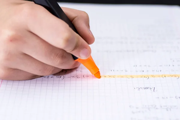 Markeerstift in Childrens hand gemarkeerde tekst in notebook. School co — Stockfoto