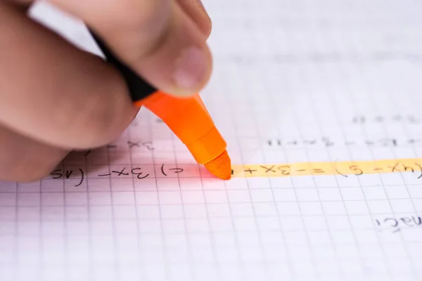 Markeerstift in Childrens hand gemarkeerde tekst in notebook. School co — Stockfoto