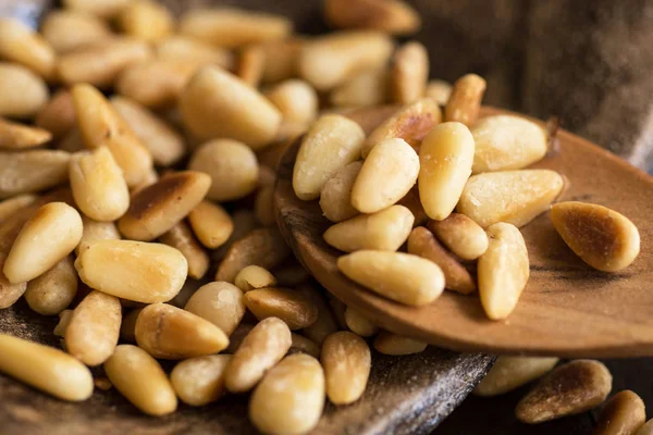 Pine Nuts on Dark Wooden Table. Toasted Organic Healthy Food.