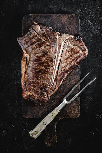 Grilled Dry Aged Beef T-bone Steak on Vintage Cutting Board