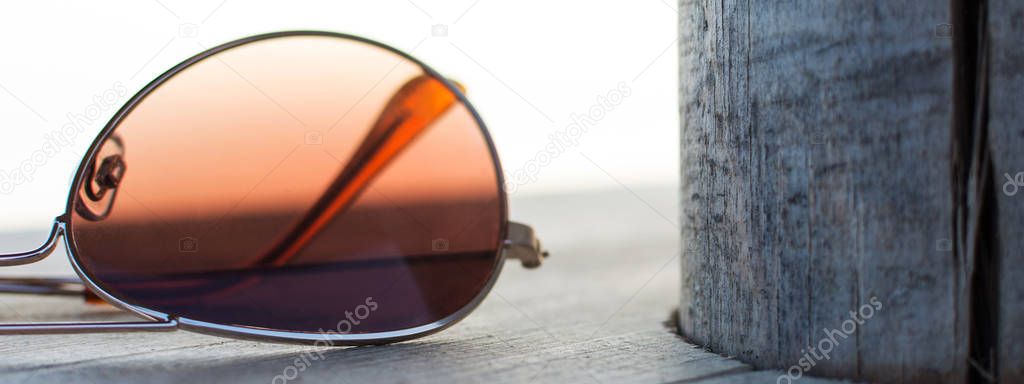Brown Mirrored Sunglasses Detail on the Wooden Background Close 