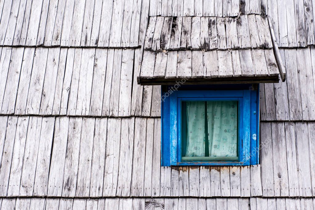 Old Blue Window on Wooden Shingles Roof House