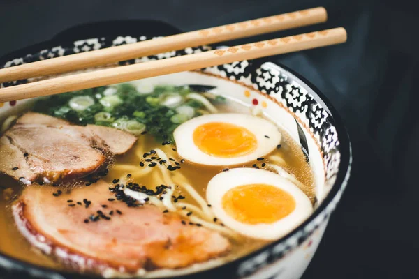 暗い背景に麺、豚肉、卵を使ったラーメンスープ — ストック写真