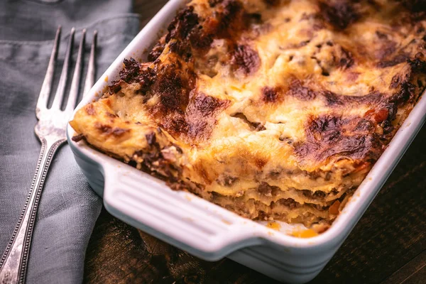 Lasagne tradizionali bolognesi su fondo rustico in legno — Foto Stock