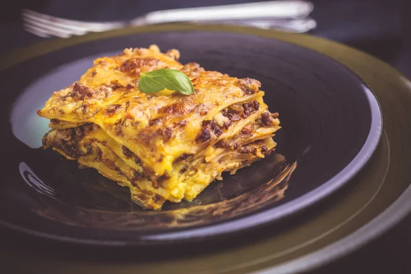 Traditional Lasagne with Minced Beef and Green Basil on Dark Plate — Stock Photo, Image