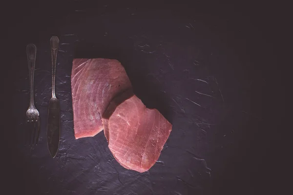 Stek z surowego tuńczyka na tle ciemnego kamienia — Zdjęcie stockowe