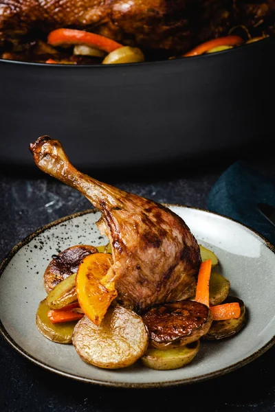 Roasted Goose Leg with Potatoes, Carrots and Oranges Royalty Free Stock Images
