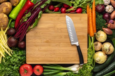 Taze Sebze Arka Plan ile Ahşap Kesme Tahtası Üzerinde Santoku Bıçak. Vegan Çiğ Gıda.