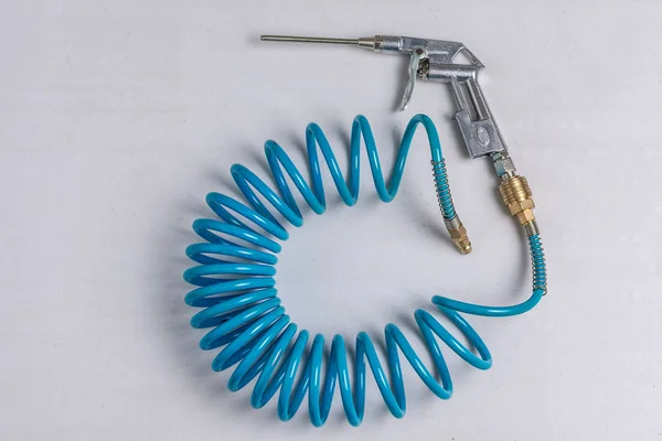 Lucht compressor Blaaspistool met opgerolde blauwe slang — Stockfoto