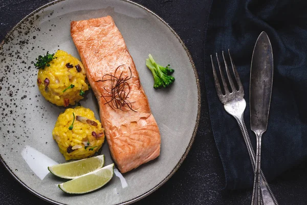 Taş Arka Plan Üzerinde Sarı Risotto ve Kireç ile Izgara Somon Biftek
