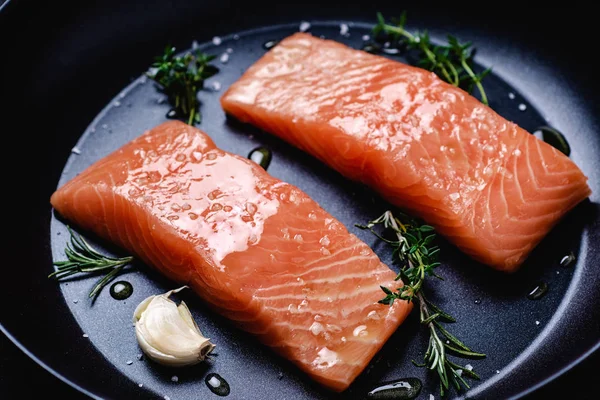 Filetes de salmão cru em frigideira com tomilho e alho pronto para cozinhar Imagens De Bancos De Imagens