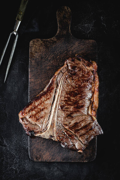 Grilled Dry Aged T-bone Steak on Rustic Chopping Board. USDA Prime Beef.