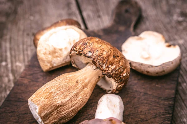 Pyszne rodzaje jadalnych dzikich grzybów na drewnianej deski tle. Przyroda i zdrowa żywność koncepcja. — Zdjęcie stockowe