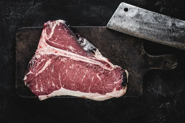 Dry Aged Beef Raw T-bone Steak on Vintage Cutting Board Stock Photo