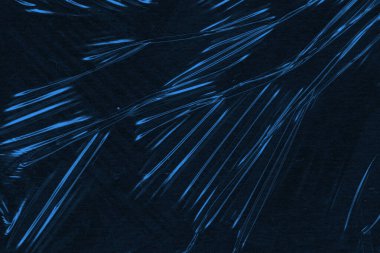 Parlak mavi ışığın dinamik çizgilerini içeren soyut makro çekim derin, karanlık bir arkaplana karşı hareket ve enerji öneriyor..