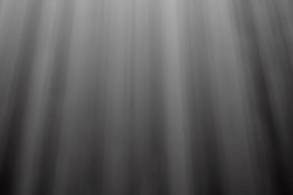 Yumuşak, dağınık dikey ışık ışınlarının yer aldığı soyut gri ölçekli arka plan derinlik ve aydınlanma hissi yaratıyor. Dokulu ve atmosferik.