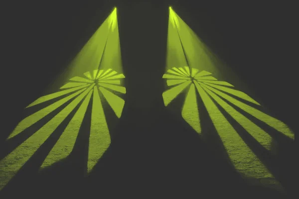 Simetrik sarı ışık huzmeleri merkez noktadan dışarıya doğru yansıyarak karanlık, dengesiz bir arkaplan karşısında farklı pervane şekilleri oluşturur..