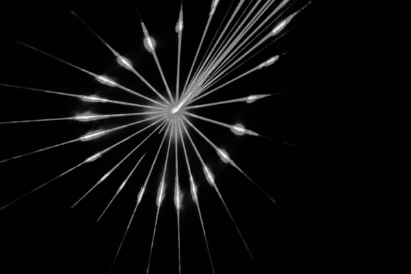 Bir yıldız patlamasının yakın çekim, siyah ve beyaz görüntüsü ya da ince çizgiler ve ışık noktalarıyla koyu siyah bir arkaplan üzerinde radyal desen.