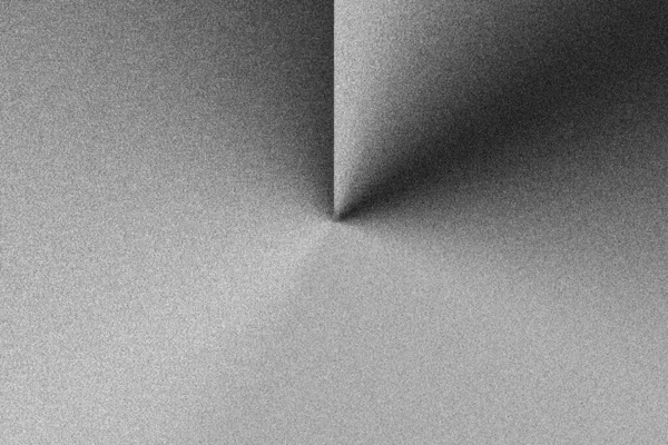 İnce taneli dokusu ve keskin kıvrımlı geometrik bir gölge yaratan gri bir tekstilin detaylı ve soyut bir görüntüsü..