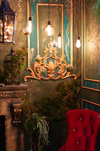 Tavanda asılı lambalar. Kırmızı sandalye. Şömine ve hücre