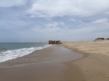 Playa de Camposoto 'daki Birinci Sığınak, San Fernando, Cadiz' de 2. Dünya Savaşı 'ndan kalma beton takviye, gelgitlerle yıpranmış, tarihi kıyı güzeliyle harmanlıyor. İspanya