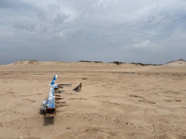 Playa de Camposoto, San Fernando, Cadiz 'in altın kumlarında parçalanmış eski ahşap gemi enkazı kıyı ve deniz tarihini gözler önüne seriyor..