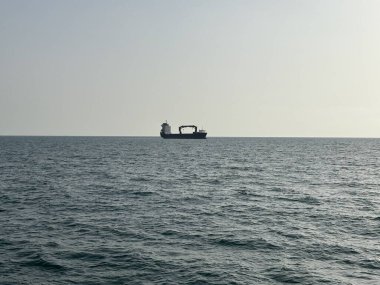 Cdiz Körfezi 'ndeki uzak ufuktaki kargo ve yolcu gemilerinin siluetleri, sakin Atlantik suları ve hareketli liman limanı yakınlarındaki açık yaz gökyüzü..