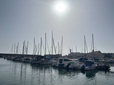 Spain: Sunny daytime views of Rota harbour, with fishing boats, marina pontoons, naval vessels, and coastal scenery in Cdiz Bay under clear Andalusian skies.