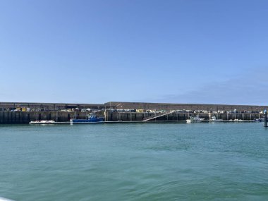 Spain: Sunny daytime views of Rota harbour, with fishing boats, marina pontoons, naval vessels, and coastal scenery in Cdiz Bay under clear Andalusian skies.