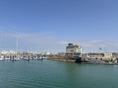 Spain: Sunny daytime views of Rota harbour, with fishing boats, marina pontoons, naval vessels, and coastal scenery in Cdiz Bay under clear Andalusian skies.