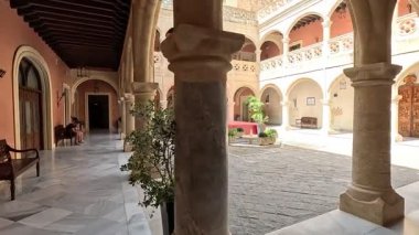 İspanya 'nın Rota kentindeki Castillo de Luna' nın merkez avlusunda yürüyün: dikdörtgen yerleşim, tepedeki kronik kuleler, mudejar fayans zodkaloları, gotik kemerler ve Endülüs kalesindeki dokulu taş duvarlar