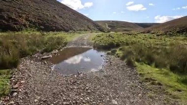 İskoçya 'nın doğu Lothian bölgesindeki Lammermuir Tepeleri' nden yukarı doğru ilerleyen Hillwalker otlakların, fundalıklarla kaplı yamaçların ve Firth of Forth ve Borders 'a doğru panoramaların ortasında.