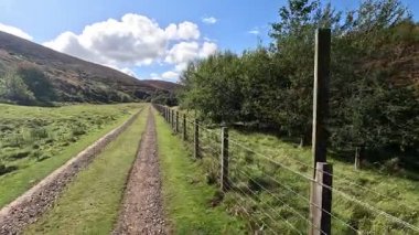 İskoçya 'nın doğu Lothian bölgesindeki Lammermuir Tepeleri' nden yukarı doğru ilerleyen Hillwalker otlakların, fundalıklarla kaplı yamaçların ve Firth of Forth ve Borders 'a doğru panoramaların ortasında.