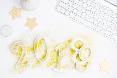 Parlak yeni yıl arka plan: golden numaraları 2018 değiştirme 2019 için yapılmış glitter masada beyaz klavye ile altın yıldız ile lüks. Yeni yıl kavramı