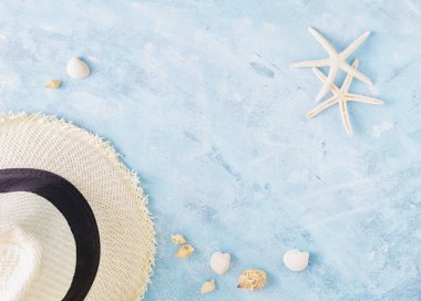 Yaz tatil mockup: hasır şapka, kabukları ve mavi zemin üzerine beyaz deniz yıldızı. Seyahat, plaj kavramı. Metin veya yazı için alan