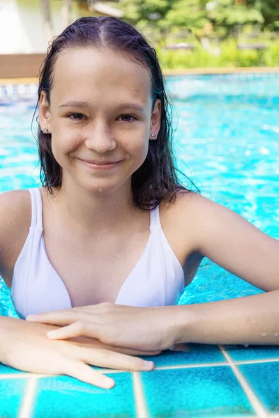 Yüzme havuzu kenarında sevimli gülümseyen varoluş kız. Seyahat, tatil, çocukluk kavramı