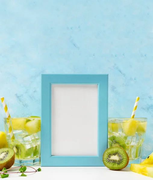 mavi Fotoğraf çerçevesi mockup: mavi arka plan üzerinde malzemelerle serin ve taze kivi karpuz limonata. Vejetaryen yemek, sağlıklı yaşam tarzı kavramı. Yaz spesiyalleri tamplate. Detoks
