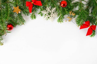 Düz manzaralı ağaç dalları üzerinde kırmızı altın oyuncaklar ve mavi arka planda köknar konileri vardı. Yeni yıl tatili kavramı. Metin uzayı