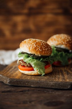 Ahşap arka planda lezzetli hamburgerler