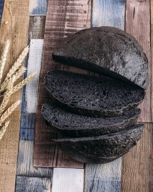 Tahtada dilimlenmiş çavdar ekmeği. Tahta bir masada. Üst görünüm