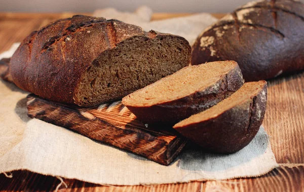 Tahtada dilimlenmiş çavdar ekmeği. Tahta bir masada. Üst görünüm