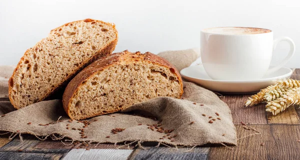 Tahta arka planda kesilmiş taze ekmek.