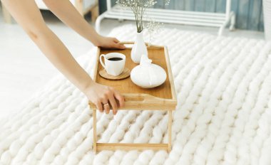 Kız yatağa kahvaltı tepsisini koyar.