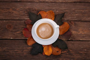 kahve ve sonbahar yaprakları ahşap arka planda