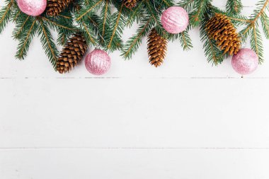 Köknar dalları ve çam kozalakları çerçeveli Noel kompozisyonu